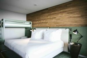 sypialnia z białym łóżkiem i drewnianą ścianą w obiekcie Octant Ponta Delgada w mieście Ponta Delgada