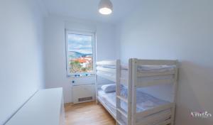 1 dormitorio con literas en una habitación con ventana en Apartment Vista Neretva, en Mostar