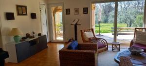 uma sala de estar com duas cadeiras e uma televisão em Villa conviviale au soleil avec piscine em Seillans
