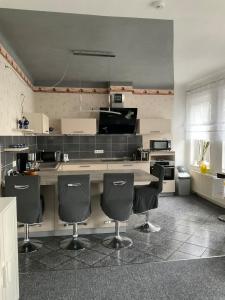 a kitchen with a counter and some chairs in it at Apartment an der Honigbar in Leipzig