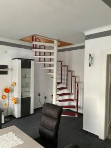una sala de estar con una escalera de caracol y una silla en Apartment an der Honigbar en Leipzig