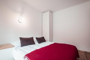 een slaapkamer met een bed met een rode deken erop bij Flat Crystal at the summit of Combloux in Combloux