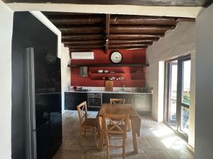 a kitchen with a table and a clock on the wall at Olive House in Kyrenia
