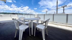 stół i 4 krzesła na balkonie w obiekcie Apartment Hotel Ecott w mieście Kagoshima