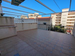 um pátio vazio com uma cerca e uma varanda em Apartamento sol y dunas em Arenales del Sol