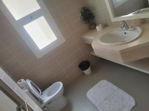 La salle de bains est pourvue de toilettes, d'un lavabo et d'une fenêtre. dans l'établissement Abutig Marina Joubal 2 Bedroom Lagoon, à Hurghada