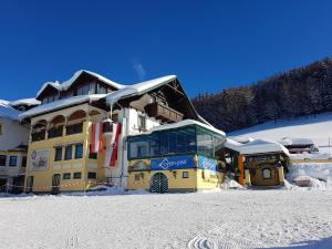 um grande edifício amarelo com neve no chão em Berggasthof Zottensberg em Edlbach