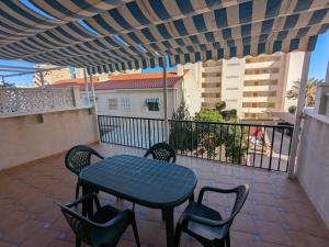 een patio met een tafel en stoelen op een balkon bij Apartamento sol y dunas in Arenales del Sol