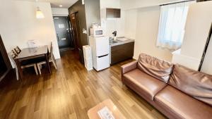 uma sala de estar com um sofá e uma cozinha em Apartment Hotel Ecott em Kagoshima