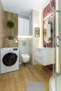 a bathroom with a washing machine and a toilet at D127 Apartament Romeo in Lublin