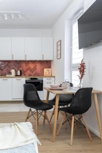 a kitchen with a wooden table and two chairs at D127 Apartament Romeo in Lublin