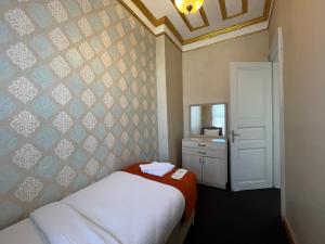 Dormitorio pequeño con cama y espejo en Le Safran Suite Hotel, en Estambul