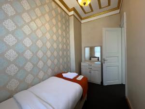 Le Safran Suite Hotel في إسطنبول: غرفة نوم صغيرة مع سرير ومرآة