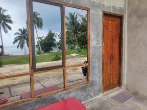 Taman Baloho Indah - Hotel & Resort في Telukdalem: غرفة مع نافذة مطلة على الشاطئ