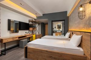 a hotel room with two beds and a desk at Afflon Hotels Loft City in Antalya