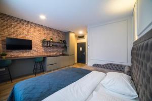 a bedroom with a bed and a brick wall at Imperial Apartment B in Zagreb