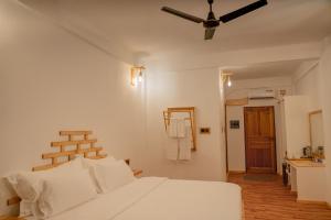 Himandhoo 的住宿－Manta Sea View Himandhoo，卧室配有白色的床和吊扇