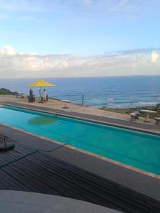 a swimming pool with a view of the ocean at Green Fields Hotel, Coffee Bay in Coffee Bay