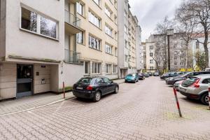 een parkeerplaats met auto's geparkeerd op een stenen straat bij Wawel Standard Apartment in Krakau