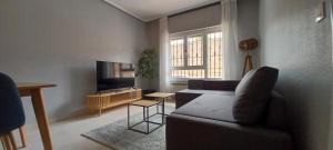 a living room with a couch and a tv at CHALET Cubo de las Monjas in Nava del Rey