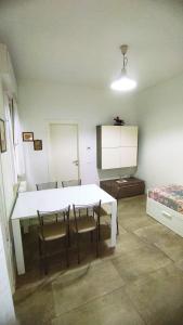 Habitación con mesa blanca, sillas y cama en Appartamento Gabriele, en Cattolica
