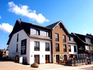 ein großes weißes Gebäude mit schwarzem Dach in der Unterkunft LODGE HOTEL Winterberg in Winterberg