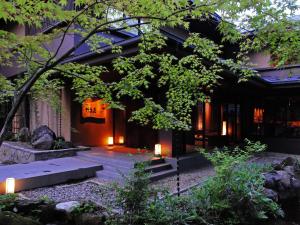 budynek z ogrodem z oświetleniem przed nim w obiekcie 竹泉荘 Chikusenso Onsen w mieście Zao