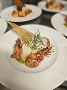 a plate of food with shrimp on a table at Lodge Hôtel de Sommedieue Verdun in Sommedieue