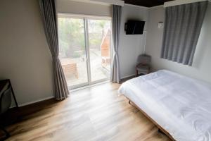 宮崎的住宿－LOCALINO STAY AOSHIMA，一间卧室设有一张床和一个大窗户