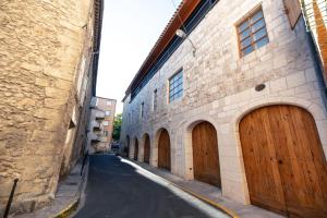 un callejón con puertas de madera marrón en un edificio en Studio familial a Mezzanine presbytère dans l'Église, en Narbona