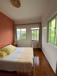 um quarto com uma cama e duas janelas em Casa Tota em Assomada