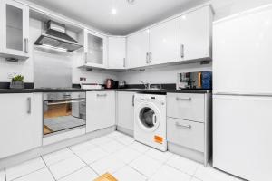 a kitchen with white cabinets and a washer and dryer at City Centre Apartment 2 Bedroom Secure Parking 201M in Birmingham