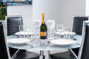 a table with glasses and a bottle of wine on it at City Centre Apartment 2 Bedroom Secure Parking 201M in Birmingham
