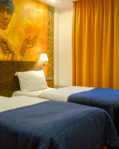 a hotel room with two beds and a painting on the wall at La Petite APARTMENTS&ROOMS in Gdańsk
