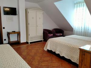 a attic bedroom with two beds and a chair at Hosteria De Langre in Langre