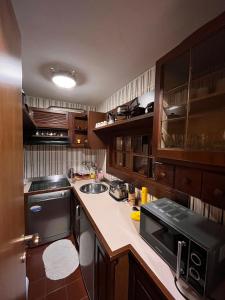 uma cozinha com armários de madeira, um lavatório e um fogão em Stella del Cervino, Ski In & Ski Out, with Garage - CIR 0464 em Breuil-Cervinia