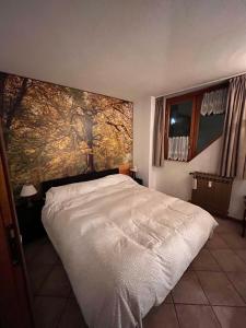 um quarto com uma cama branca e uma grande pintura na parede em Stella del Cervino, Ski In & Ski Out, with Garage - CIR 0464 em Breuil-Cervinia