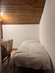 uma cama num quarto com tecto em madeira em Stella del Cervino, Ski In & Ski Out, with Garage - CIR 0464 em Breuil-Cervinia