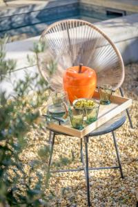 un vaso arancione seduto su un tavolo con gli occhiali di L'annexe des Alpilles a Maussane-les-Alpilles