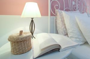 an open book on a table next to a lamp at Dida moj in Senj