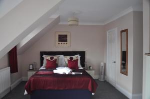 a bedroom with a bed with a red bedspread at Hotel Peppers in Torquay