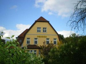 Una casa amarilla con la palabra Berlín. en Pension Villa Martha, en Burg Stargard