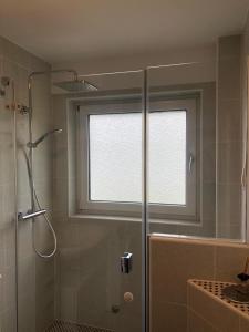 La salle de bains est pourvue d'une douche et d'une fenêtre. dans l'établissement Ferienwohnung Montabaur, à Montabaur