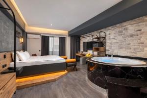 Afflon Hotels Loft City في أنطاليا: غرفة الفندق بسرير وحوض استحمام
