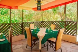 a table with chairs and a tent on a patio at Mara Olodare in Ololaimutiek