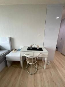 a white desk with a chair in a room at Apartement Treepark BSD in Dadap