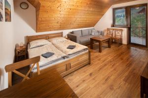 ein Schlafzimmer mit Bett und ein Wohnzimmer in der Unterkunft Apartmány Aram Kubínska hoľa in Dolný Kubín