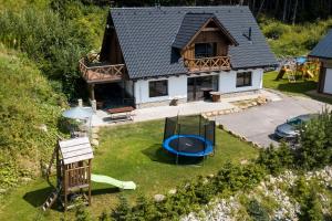 eine Luftaufnahme eines Hauses mit einem Spielplatz in der Unterkunft Apartmány Aram Kubínska hoľa in Dolný Kubín