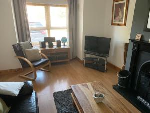 a living room with a fireplace and a tv at Tramore Holidays in Tramore