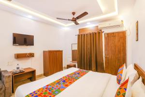 a bedroom with a bed and a ceiling fan at FabHotel Duke Inn in Bhopal